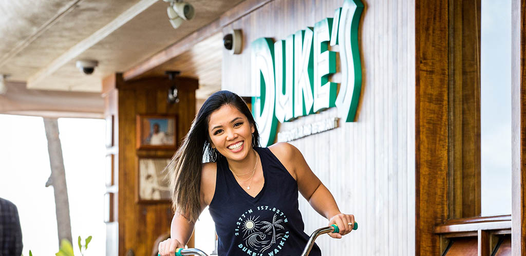 A woman riding a bike at Duke’s Waikiki