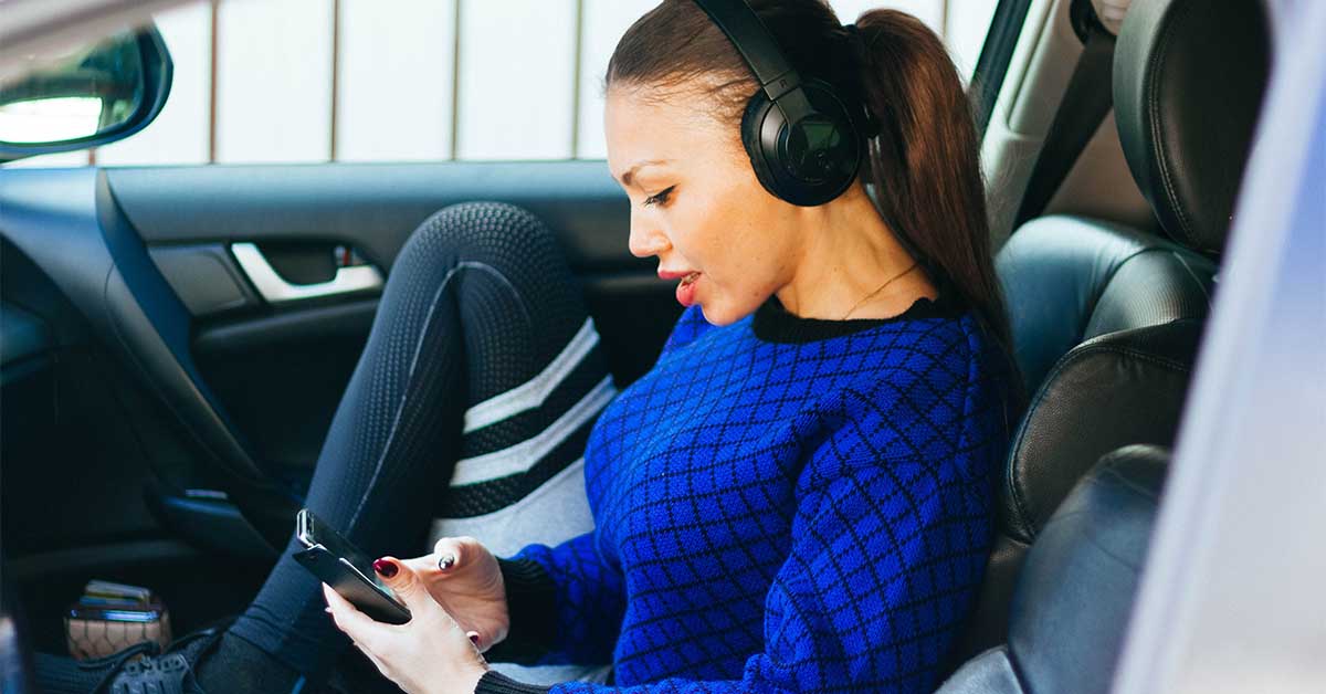 Mujer leyendo sus mensajes de texto en un coche