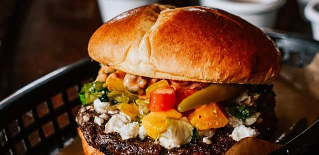 A burger with all the toppings from Happy Dog