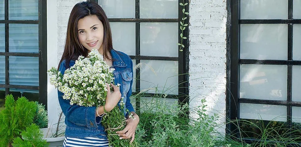 A beautiful Thai MILF holding a bouquet of flowers