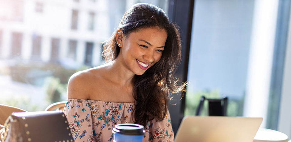 Beautiful Filipino woman using laptop at cafe