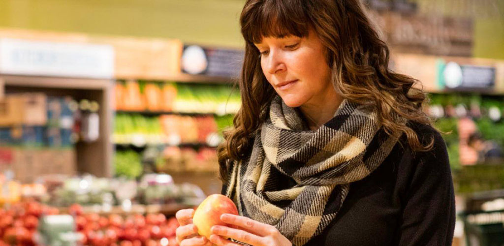A woman shopping for peaches at Whole Foods