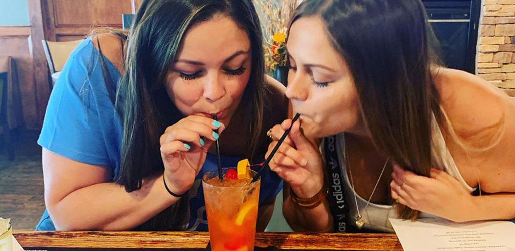 Two beautiful women sharing a cocktail at Tyler's Restaurant