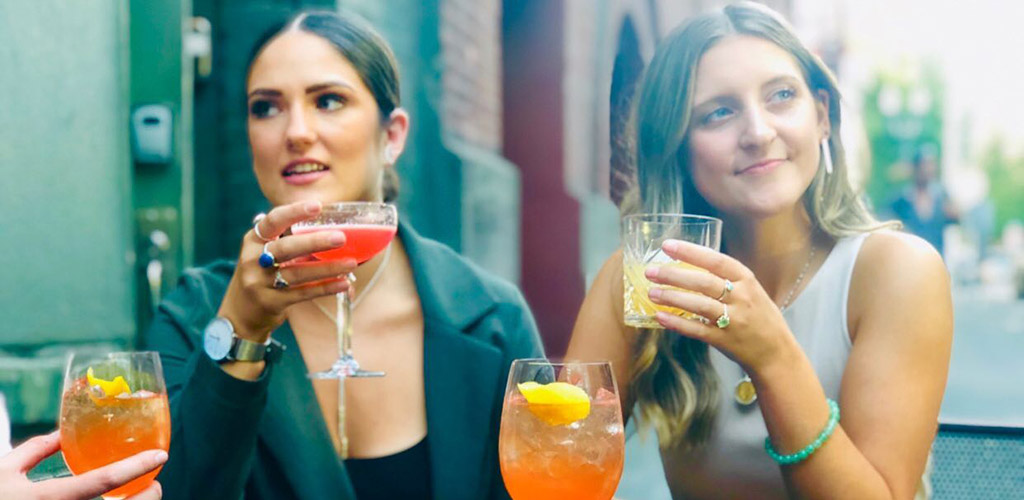 Two women with cocktails at the patio of Vault Cocktail Lounge