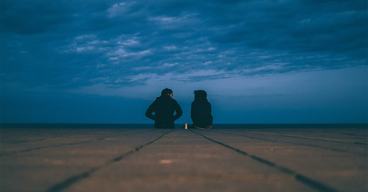 Man and woman talking at sunset