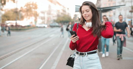 Woman checking out the best dating apps in Philadelphia while walking