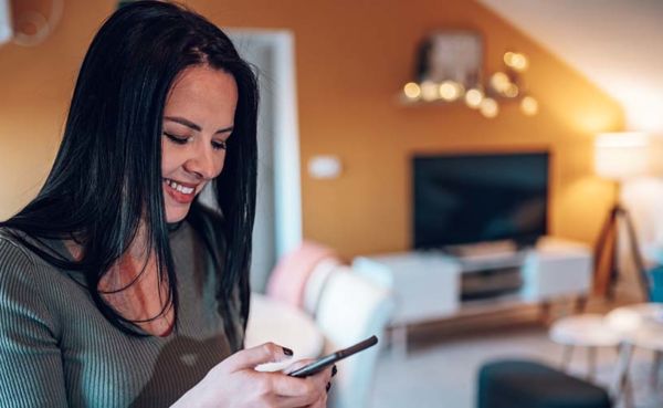 A woman checking out the best dating apps in San Antonio while at home