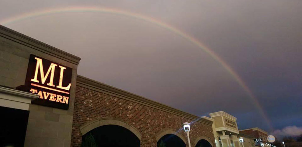 Rainbow over the ML Tavern which is brick and grey stone