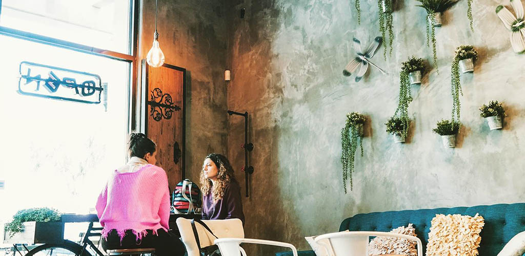 Two girls having coffee in the industrial-inspired interior of Coffee Religion