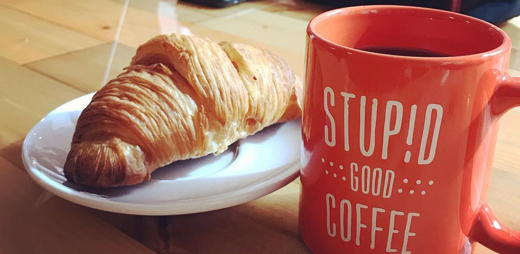 Een croissant en koffie van Stupid Good Coffee