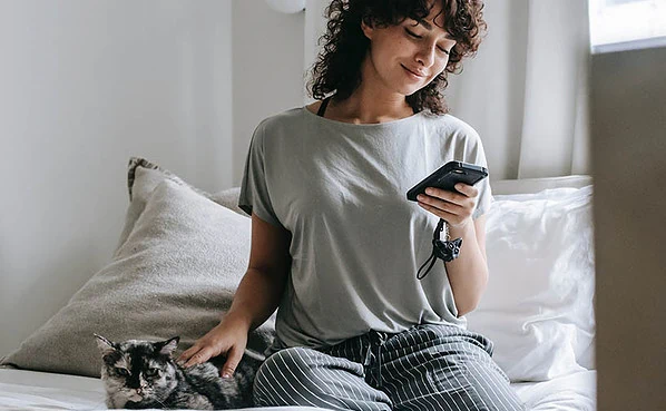 She's smiling because she's texting a guy who knows how to build sexual tension over text