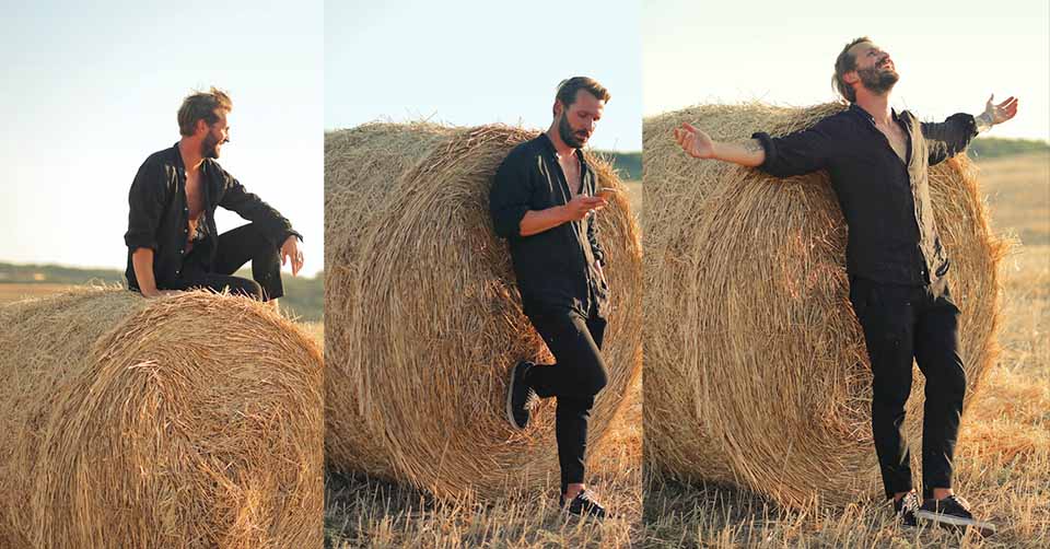 Man posing in front of a hay bale