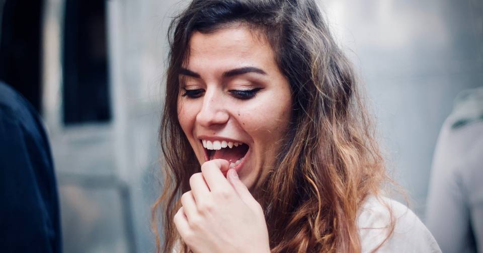 Woman laughing and thinking about a guy