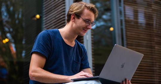 An INFJ man typing on his laptop