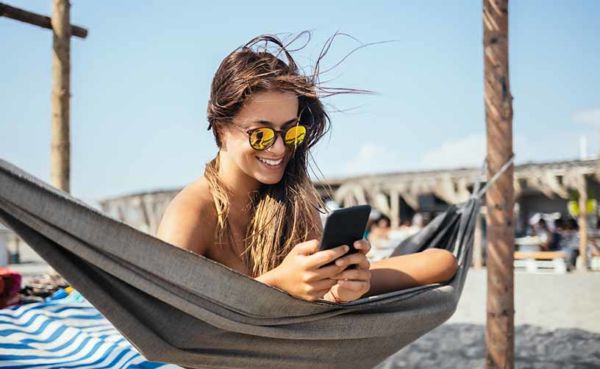 A beautiful woman using a San Juan dating app at the beach
