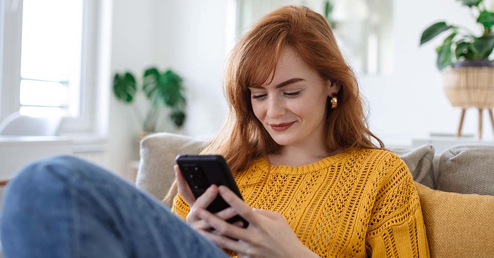 A woman using the best dating apps in Madison while on the couch