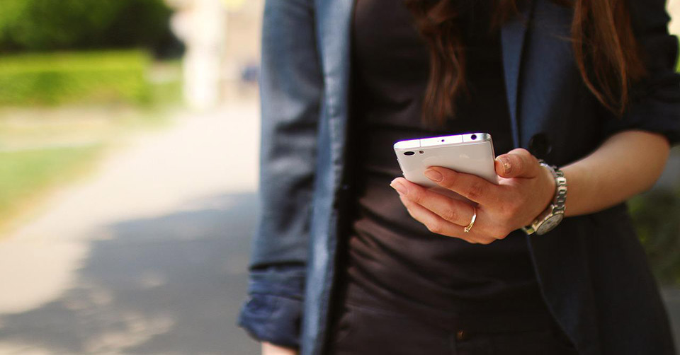Woman checking out free dating apps while walking