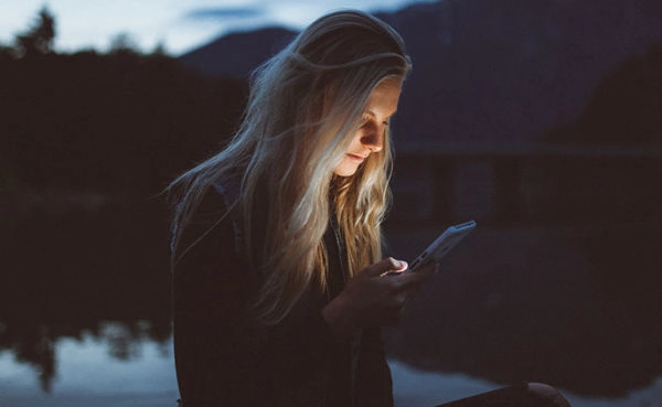 A woman using Washington dating apps while at the lake