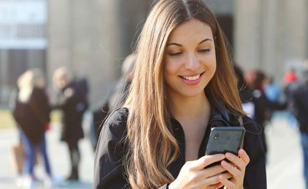 A young woman using a Vermont dating app while on her way to class