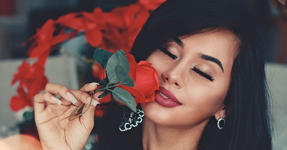 Beautiful woman caressing a rose