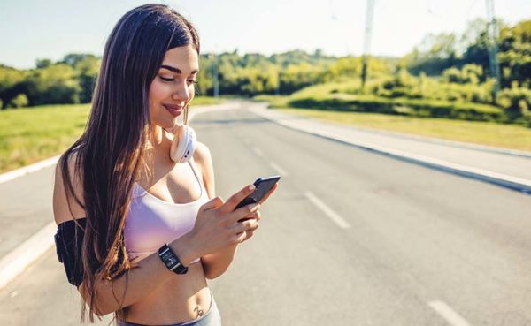 A fit woman using a Kentucky dating app while jogging