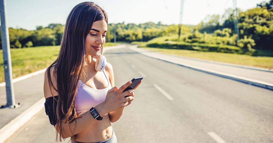 A fit woman using a Kentucky dating app while jogging