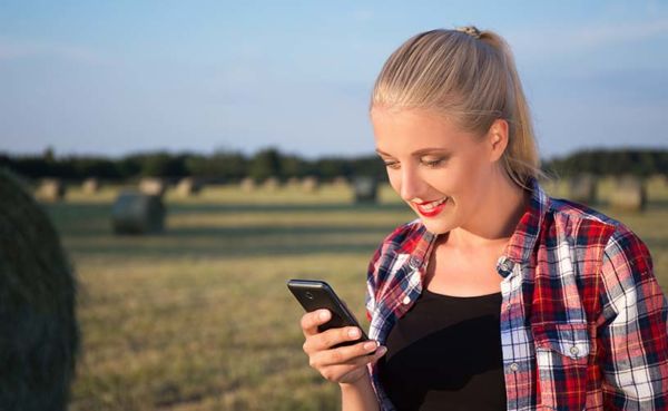 Woman checking out some Wyoming dating apps while in a field