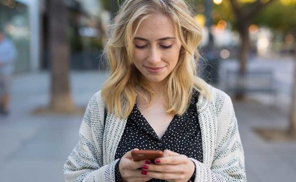 Woman in a cardigan using a Maine dating app to find a date