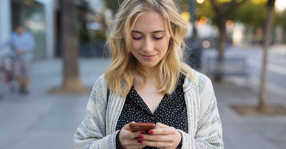 Woman in a cardigan using a Maine dating app to find a date