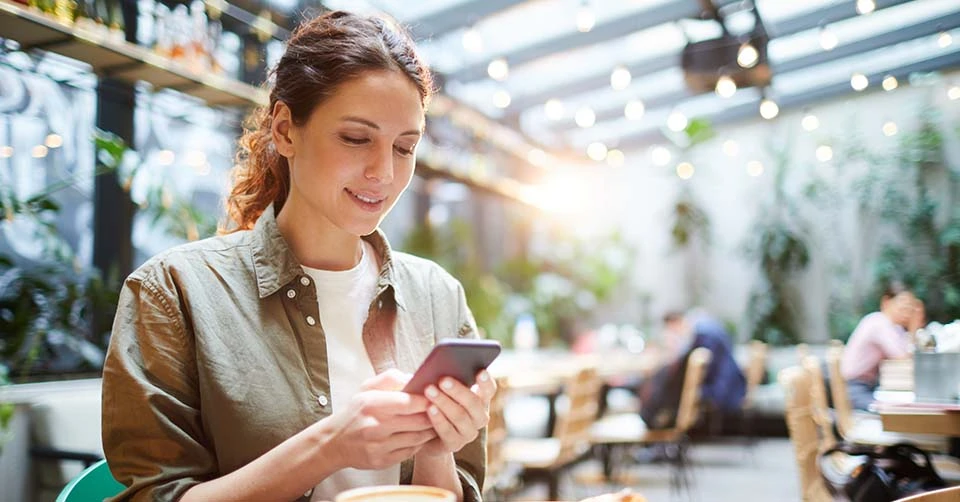 A woman at a cafe using her favorite West Virginia dating app