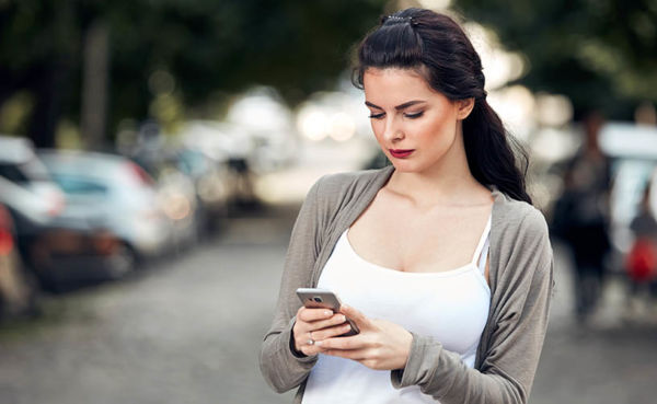 A young brunette woman using a Manchester dating app