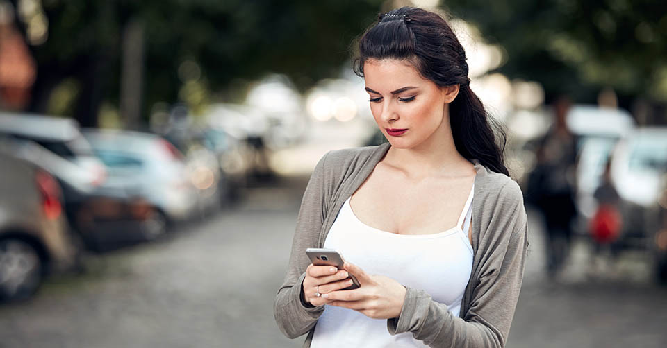 A young brunette woman using a Manchester dating app