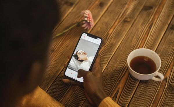 Man comparing Tinder and Adult Friend Finder apps for dating success in 2025