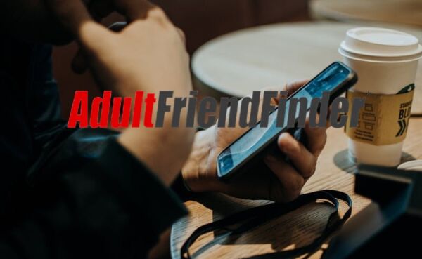 Man texting on his phone at a city cafe planning a first meetup from an online chat