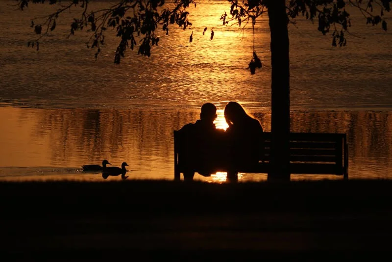 Couple walking on the Chicago Riverwalk at sunset with the skyline behind them