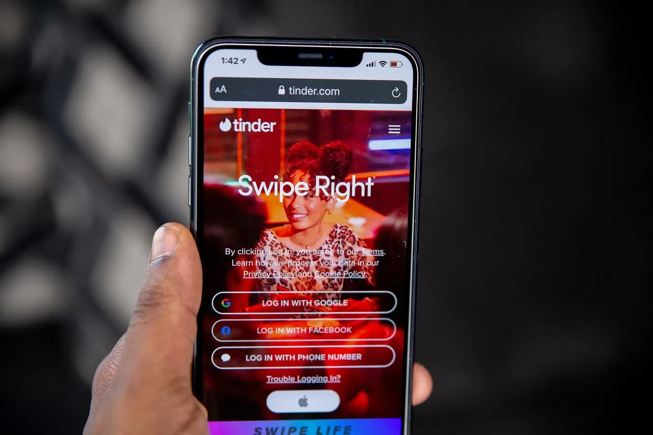 Closeup of a person swiping on a dating app at a cafe