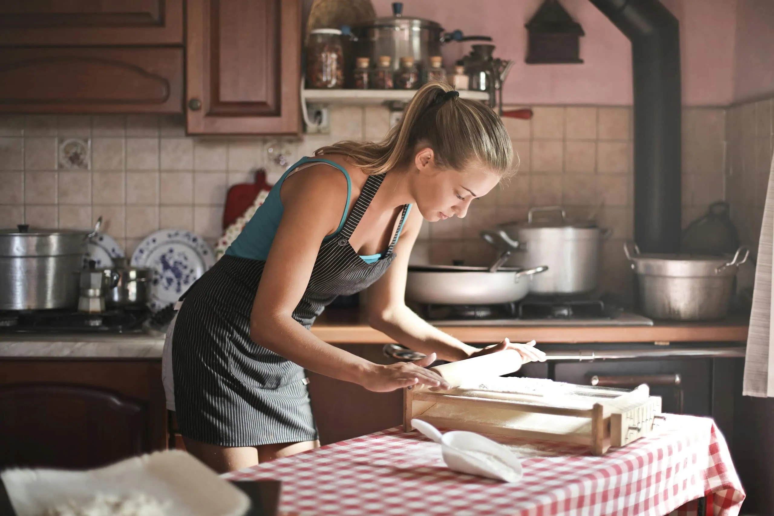 Woman representing traditonal wife values, cooking in kitchen