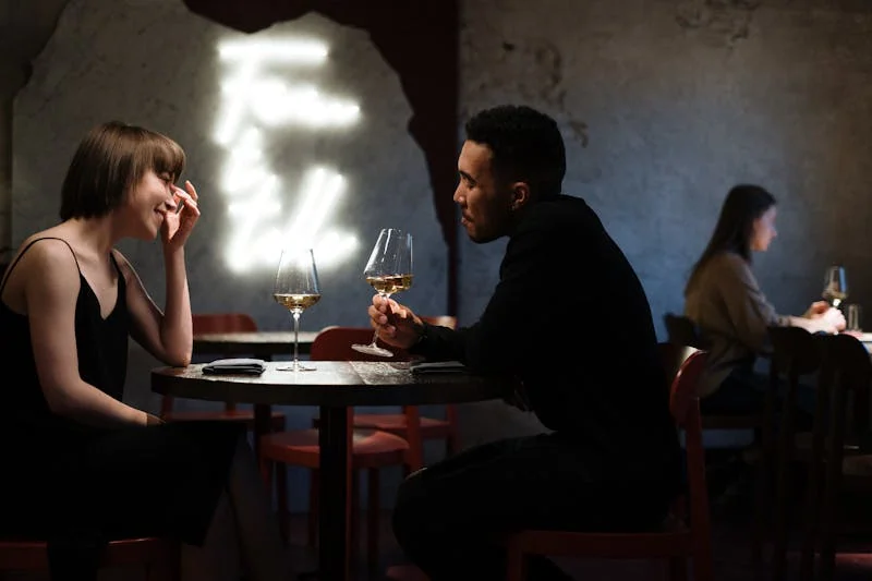 Young couple enjoying a casual date at a cozy urban bar with smartphones, showcasing modern dating in 2025.