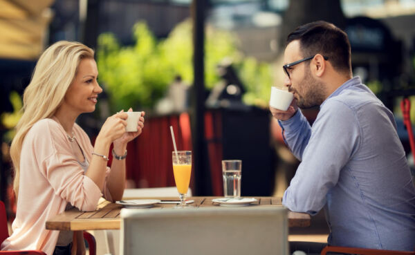 Young couple on a successful local dating app coffee date in vibrant city neighborhood, representing effortless nearby connections in 2025.