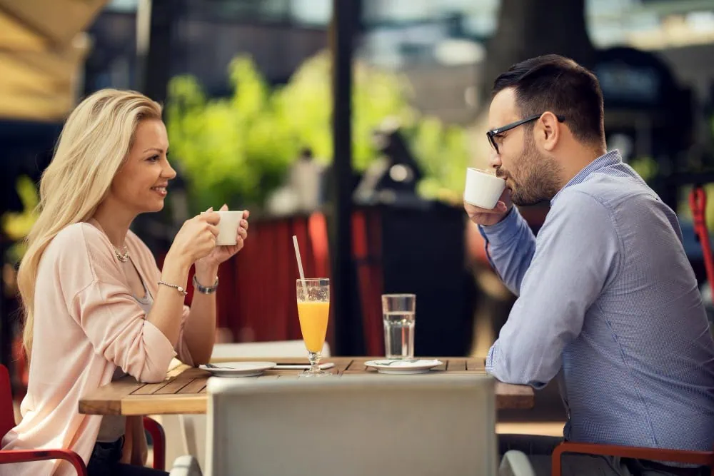 Young couple on a successful local dating app coffee date in vibrant city neighborhood, representing effortless nearby connections in 2025.