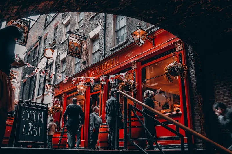 Friends and strangers engaging in easy conversation at a cozy London bar, demonstrating ideal venues for navigating casual connections in person.