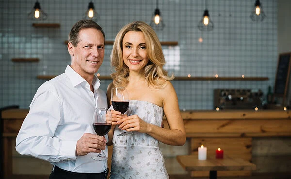 Mature couple in their 40s browsing dating app on smartphone at cafe