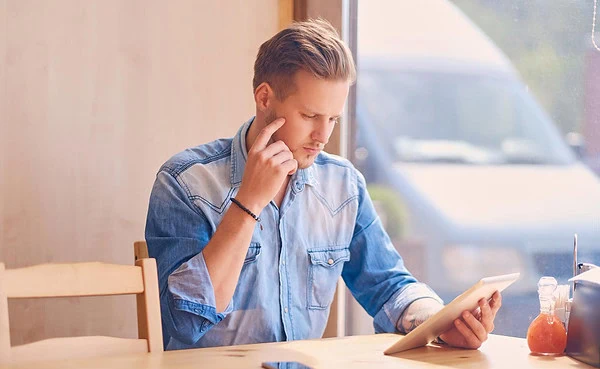 Person reviewing online subscription pricing plans on laptop screen while making purchasing decision