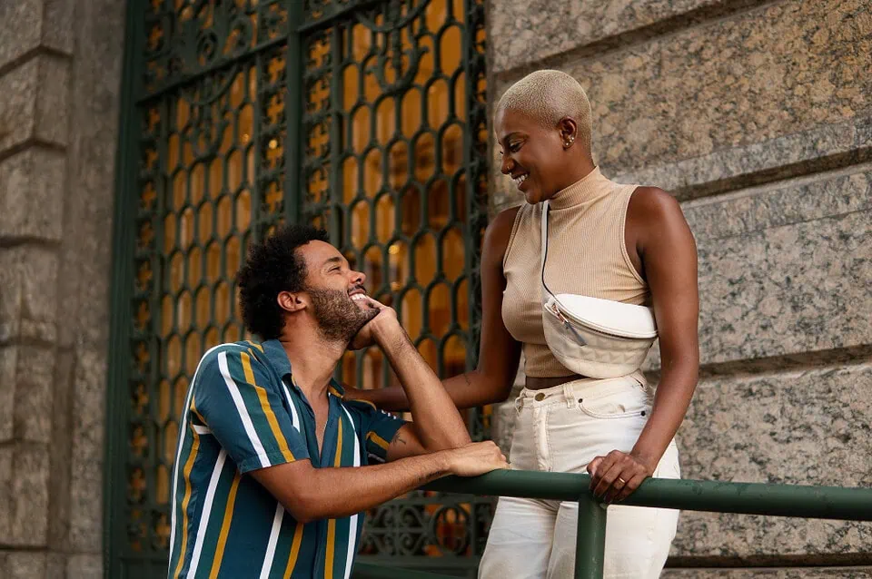Diverse young couple enjoying a walk in a sunny urban setting with jacaranda trees, symbolizing modern dating connections via apps in a city like Pretoria, photorealistic image for dating blog header.