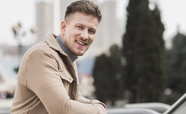 Confident smiling man outdoors in natural light, representing success on casual dating apps like Adult Friend Finder