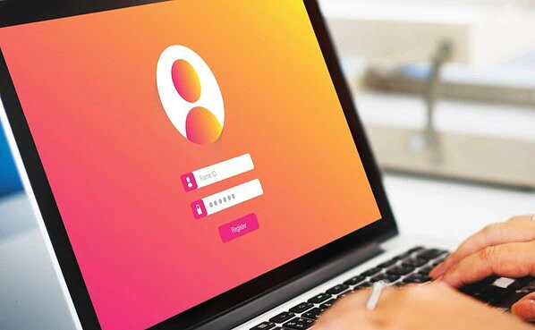 A laptop on a desk showing a login page representing dating site security.