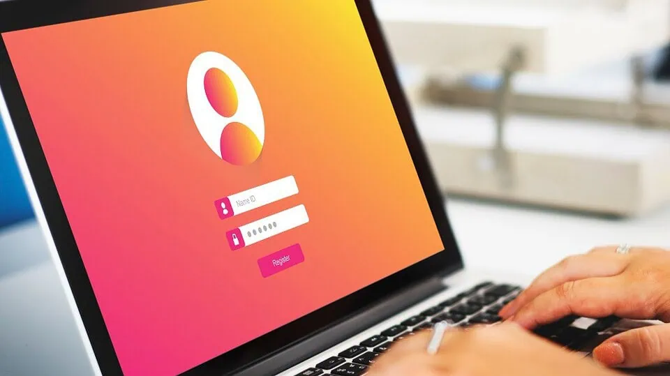 A laptop on a desk showing a login page representing dating site security.